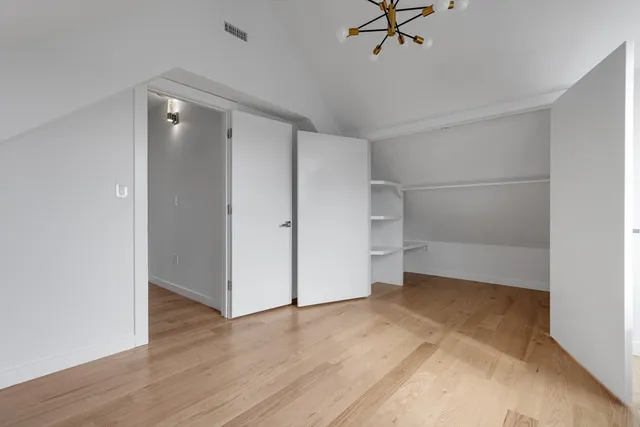 a view of a room with wooden floor and a ceiling fan