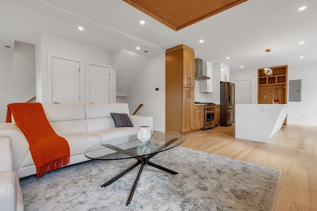 69 Boston Avenue, Unit 69 Somerville, MA 02144 - Photo 4 of 26 a living room with furniture and kitchen view