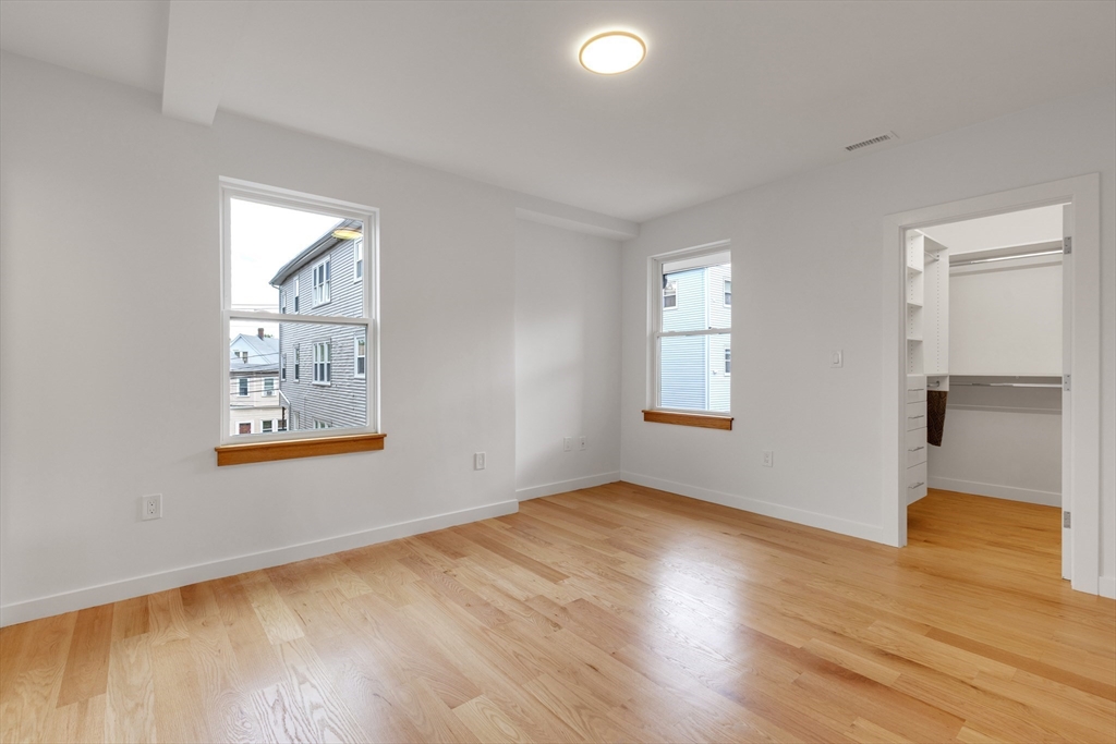 69 Boston Avenue, Unit 69 Somerville, MA 02144 - Photo 8 of 26 a view of an empty room with wooden floor and a window