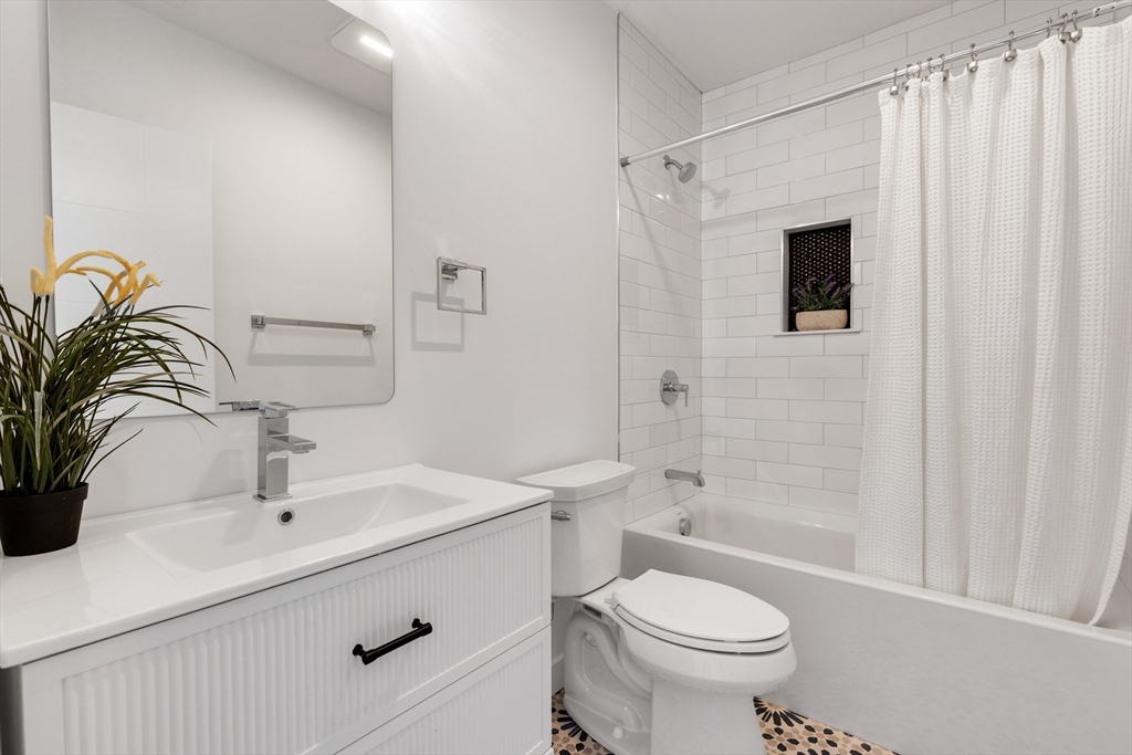 69 Boston Avenue, Unit 69 Somerville, MA 02144 - Photo 9 of 26 a bathroom with a sink a toilet and shower