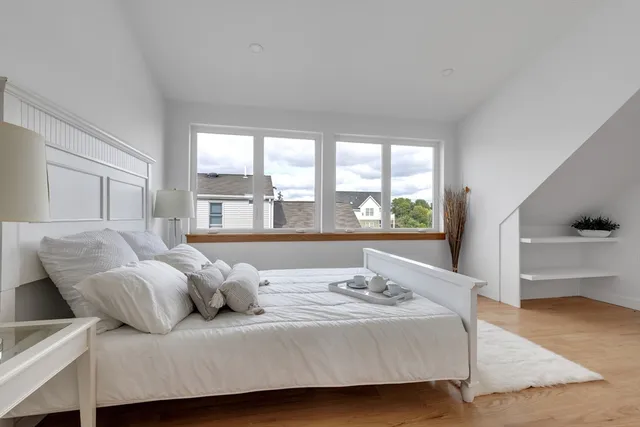 a bedroom with a bed and a large window