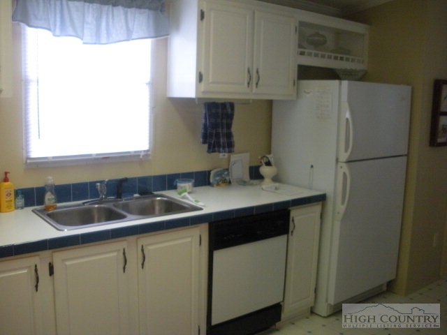 73 Smith Acres Road Ennice, NC 28623 - Photo 20 of 22 a kitchen with a sink a refrigerator and cabinets