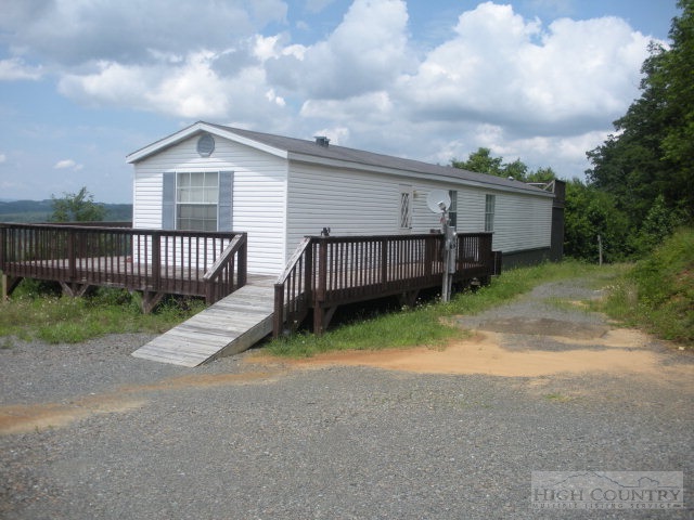 73 Smith Acres Road Ennice, NC 28623 - Photo 2 of 22 a view of a house with a yard and wooden fence