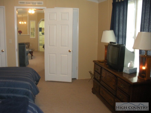 73 Smith Acres Road Ennice, NC 28623 - Photo 6 of 22 a bedroom with a bed and a lamp on table