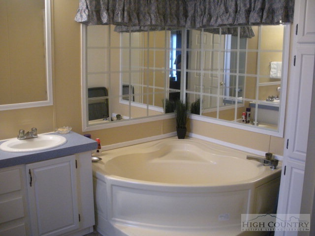 73 Smith Acres Road Ennice, NC 28623 - Photo 7 of 22 a bathroom with a sink and a bathtub