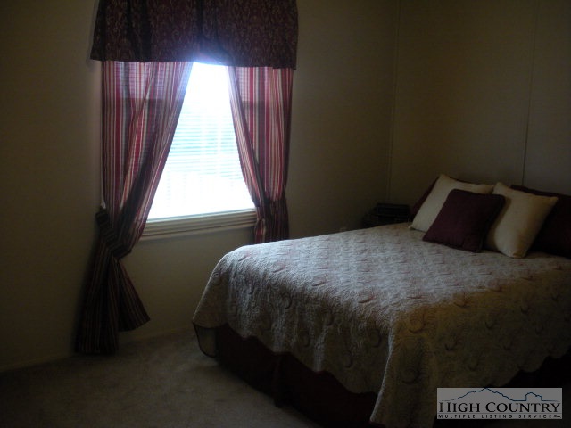 73 Smith Acres Road Ennice, NC 28623 - Photo 10 of 22 a bedroom with a bed and a window