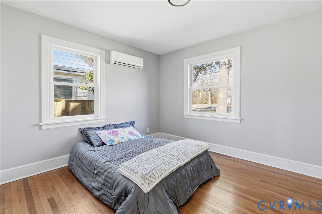 5607 Jahnke Road Richmond, VA 23225 - Photo 19 of 28 Bedroom with a wall unit AC and wood-type flooring
