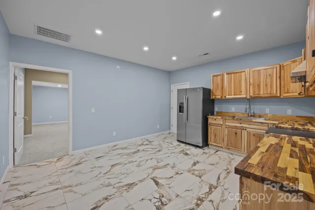 a kitchen with stainless steel appliances granite countertop a refrigerator and a stove top oven