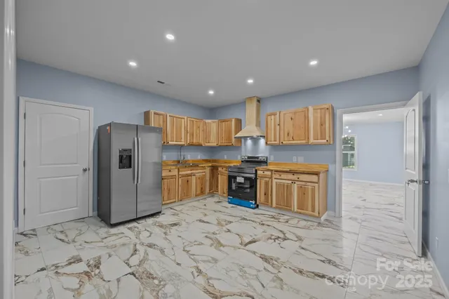 a kitchen with stainless steel appliances granite countertop a refrigerator and a sink