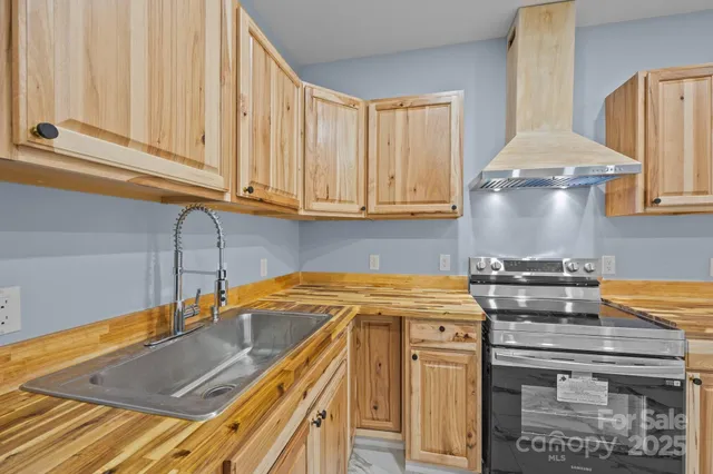 a kitchen with stainless steel appliances granite countertop a sink stove and cabinets