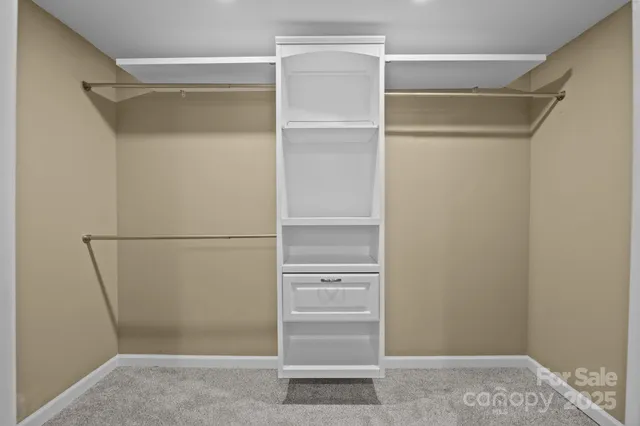 a view of walk in closet with empty racks