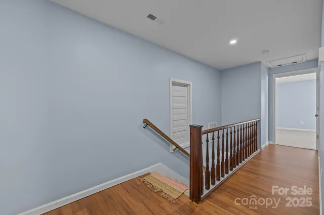 a view of a hallway with wooden floor and entryway