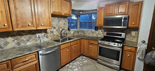 a kitchen with granite countertop cabinets stainless steel appliances and a counter space