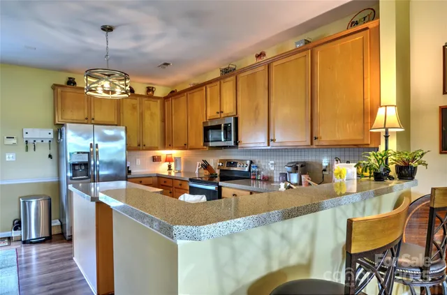 a kitchen with granite countertop a sink appliances and cabinets