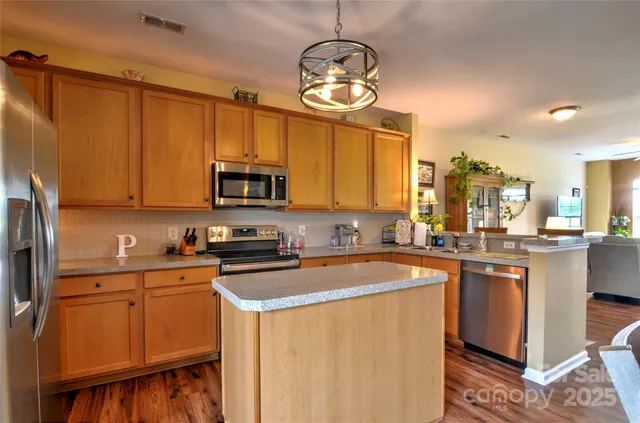 a kitchen with stainless steel appliances a stove refrigerator sink and cabinets