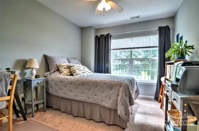 a bedroom with a bed a flat screen tv and a large window