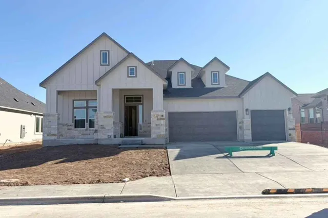 a view of a house with a small yard and large tree