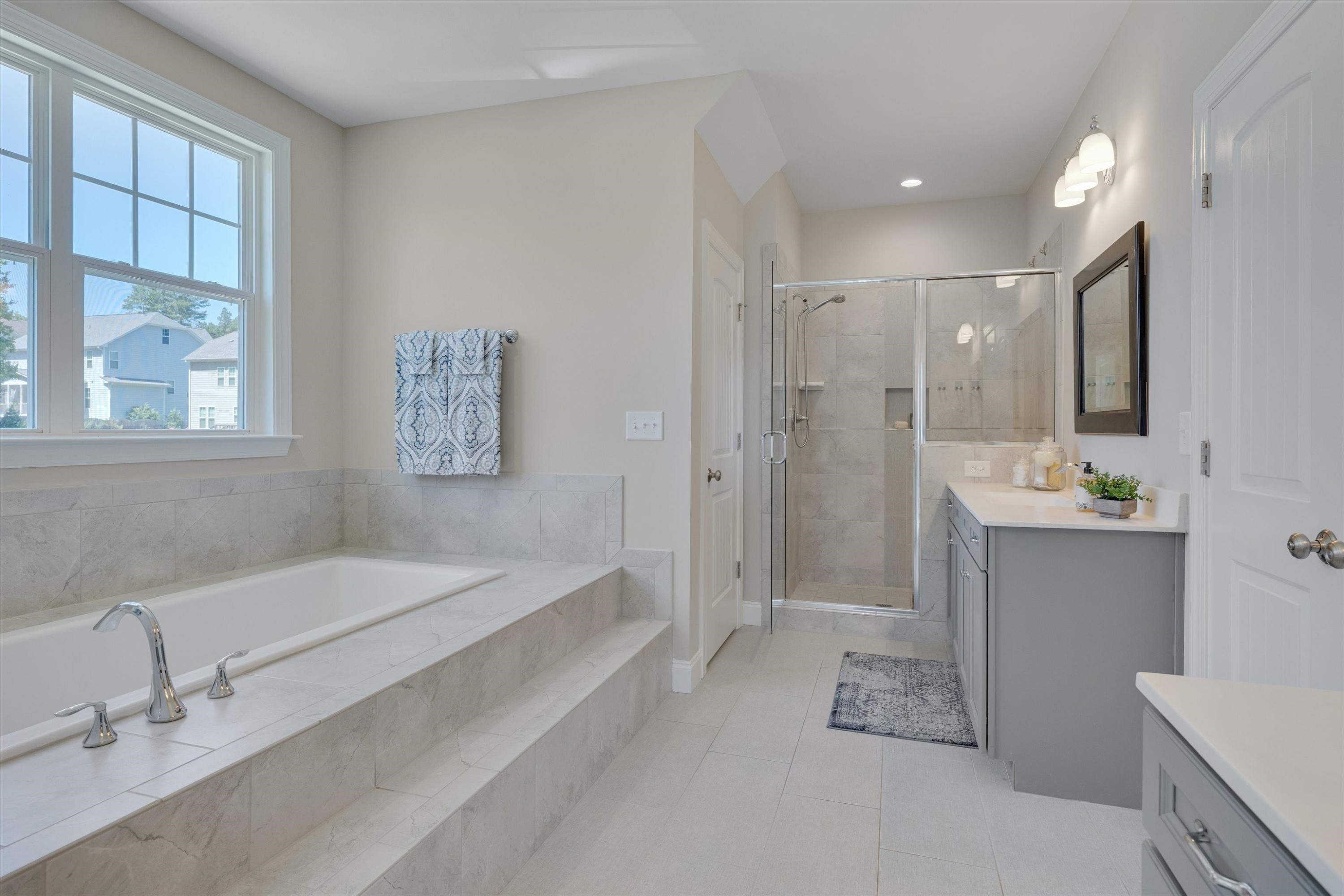 2617 Needle Pine Drive Apex, NC 27539 - Photo 18 of 42 a spacious bathroom with a bathtub shower sink and mirror