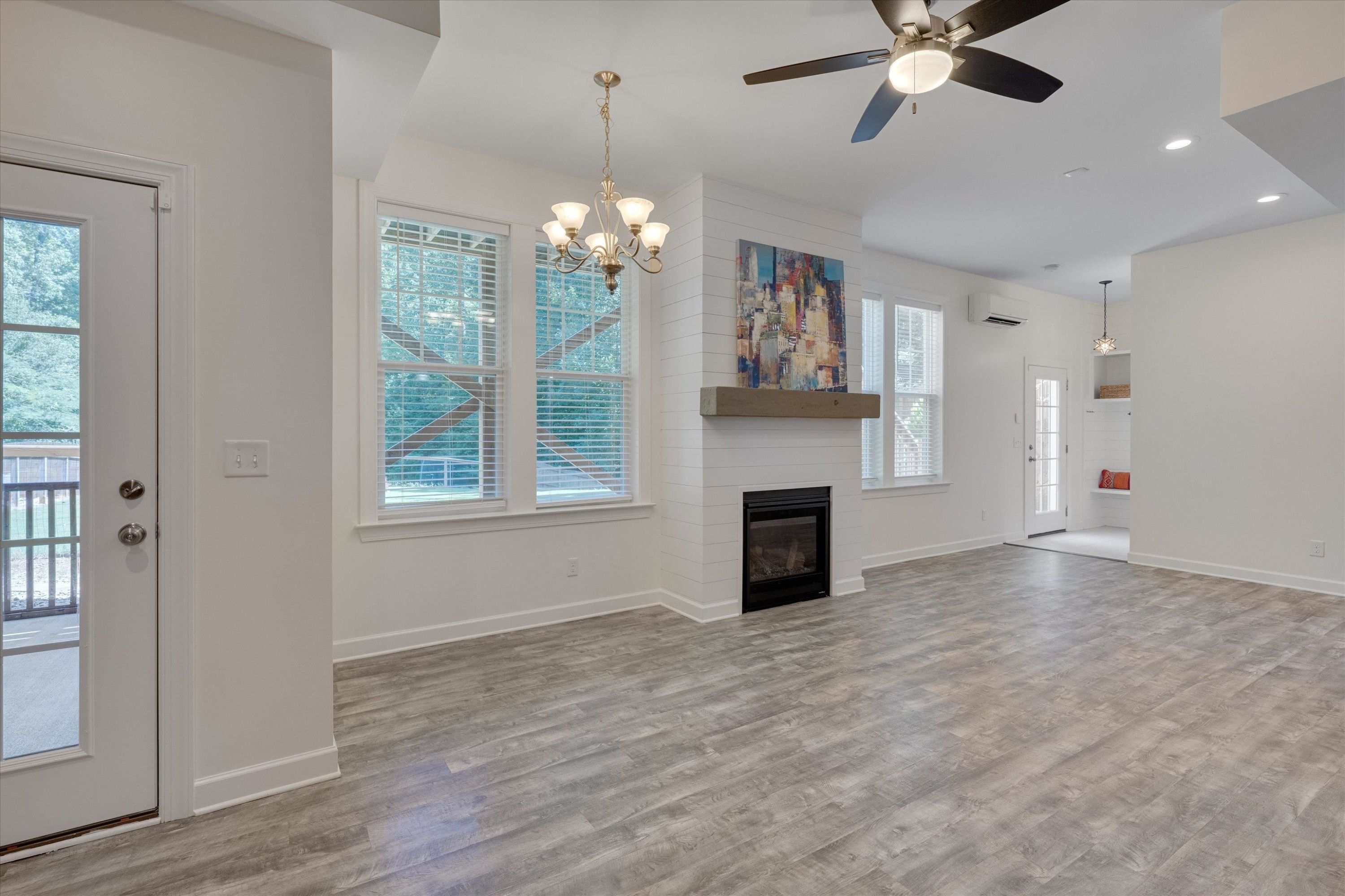 2617 Needle Pine Drive Apex, NC 27539 - Photo 25 of 42 an empty room with windows chandelier and fireplace
