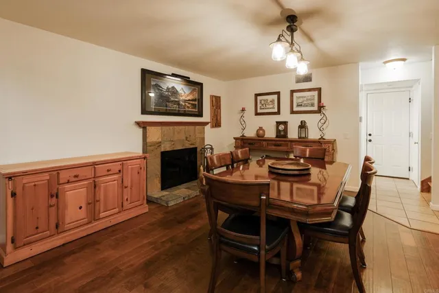 a dining room with furniture a chandelier and wooden floor