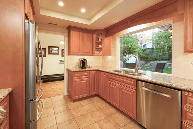 a kitchen with stainless steel appliances granite countertop a stove a sink and a refrigerator