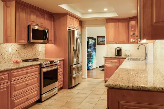 a kitchen with stainless steel appliances granite countertop a stove a sink and a microwave