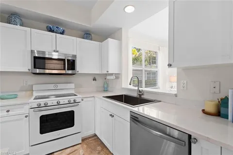 a kitchen with granite countertop a sink a stove a microwave and wooden cabinets