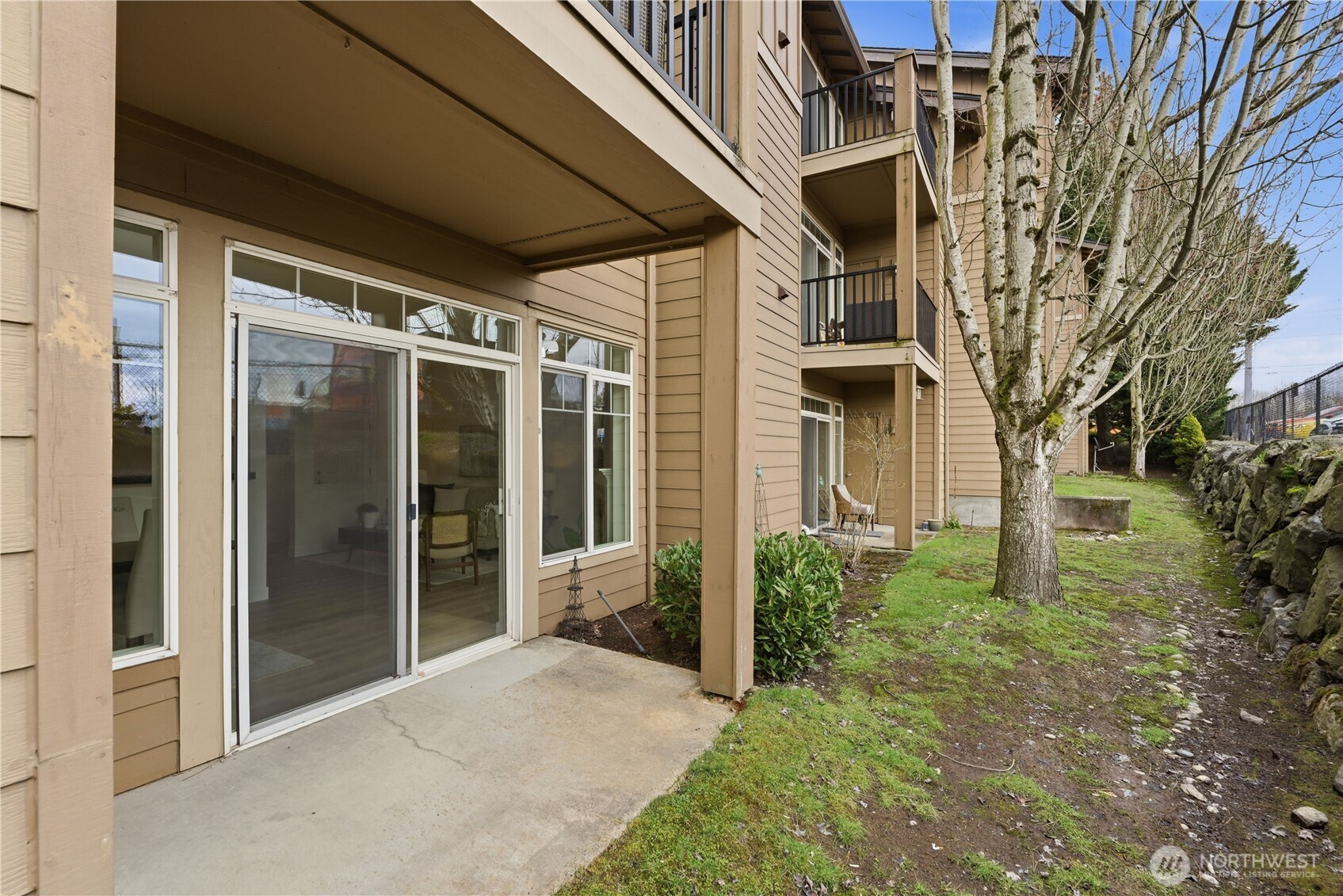 18930 Bothell Everett Highway, Unit G105 Bothell, WA 98012 - Photo 4 of 21 a view of a brick house with a large windows and a large tree