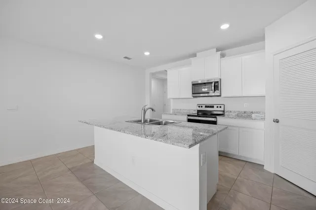a kitchen with appliances a sink and cabinets