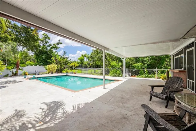 a view of a patio with a table chairs and a backyard