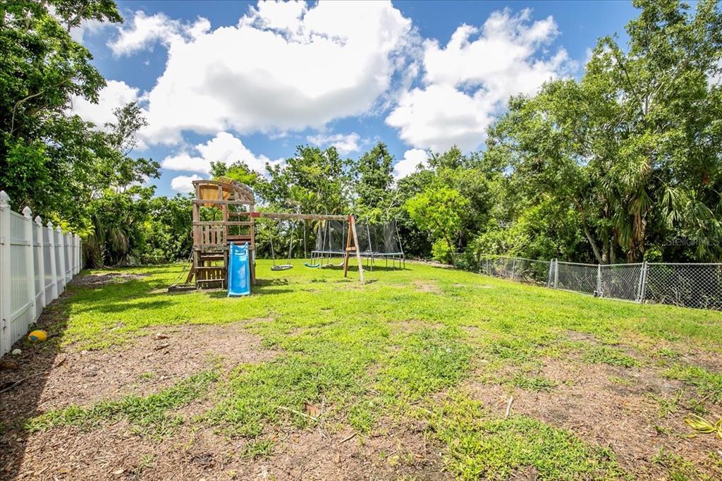 1302 Georgetowne Circle Sarasota, FL 34232 - Photo 25 of 28 a swimming pool with wooden fence