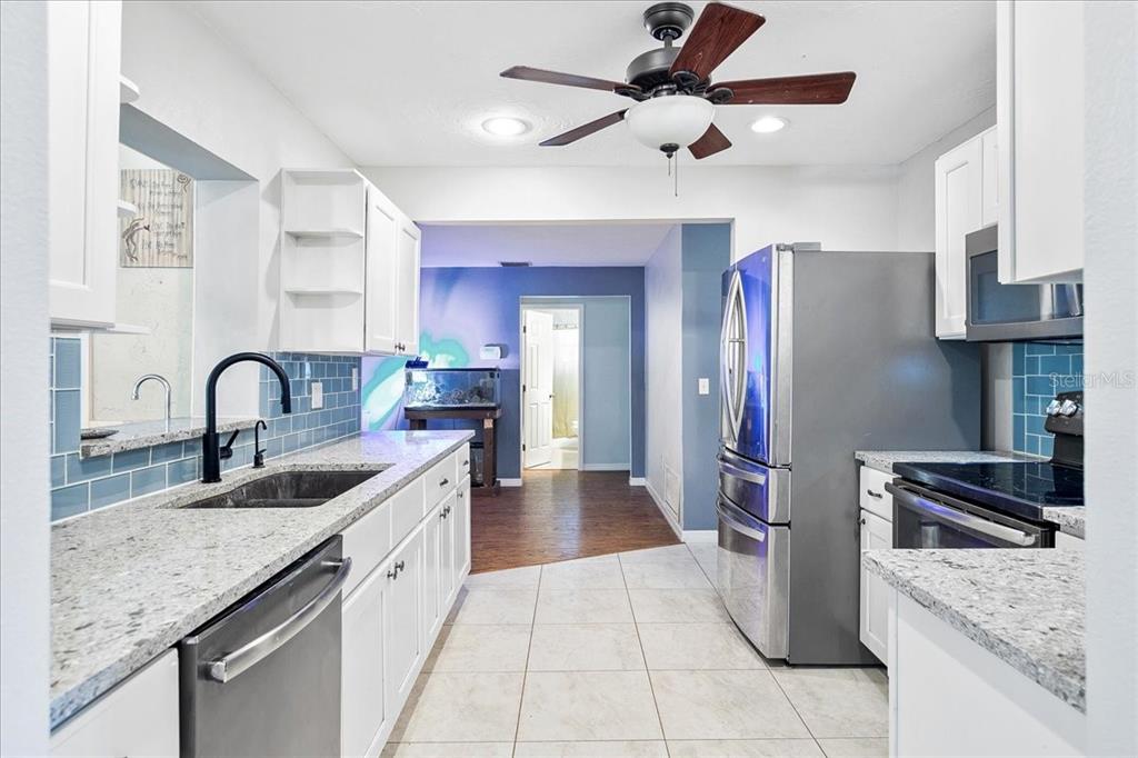 1302 Georgetowne Circle Sarasota, FL 34232 - Photo 8 of 28 a kitchen with stainless steel appliances granite countertop a sink stove and refrigerator
