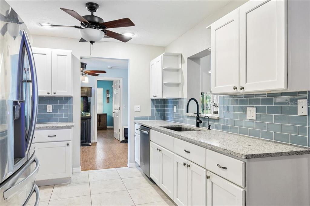 1302 Georgetowne Circle Sarasota, FL 34232 - Photo 9 of 28 a kitchen with granite countertop a sink stainless steel appliances and cabinets