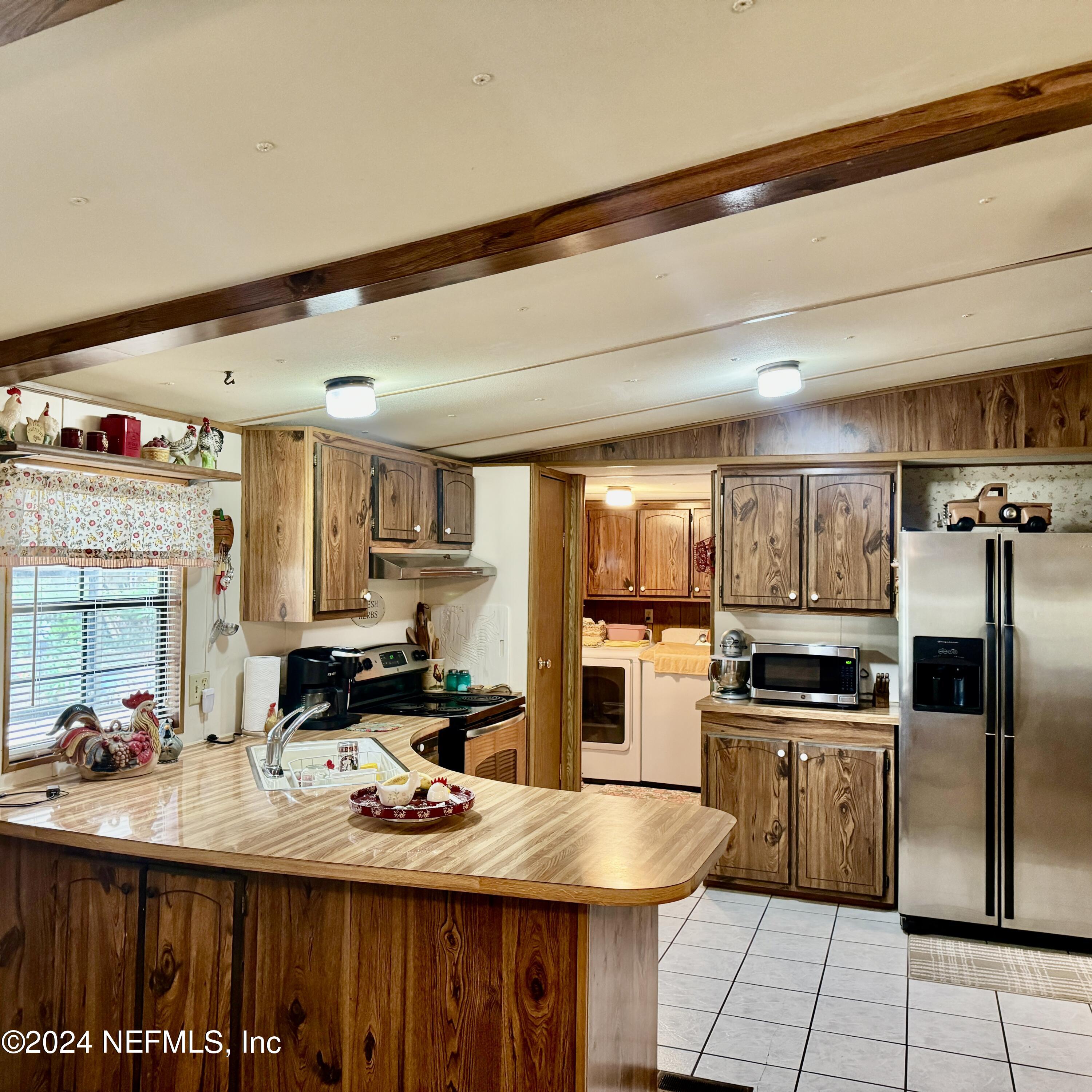 105 George Avenue Interlachen, FL 32148 - Photo 18 of 29 a kitchen with refrigerator and cabinets