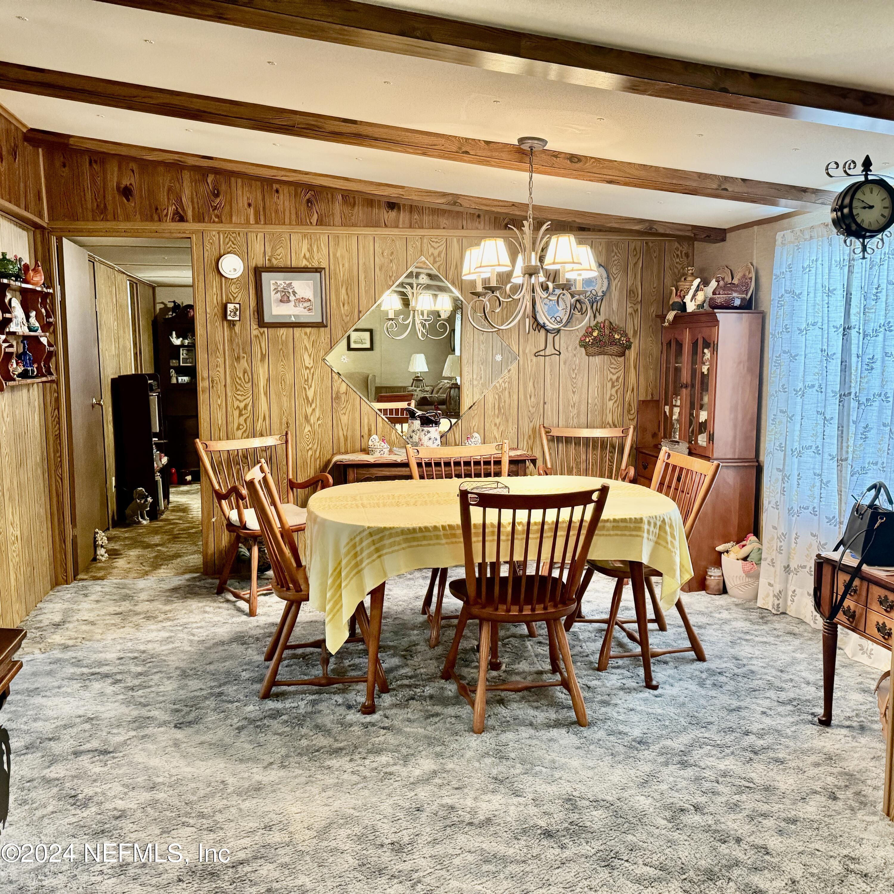 105 George Avenue Interlachen, FL 32148 - Photo 23 of 29 a view of a dining room with furniture a chandelier and kitchen view