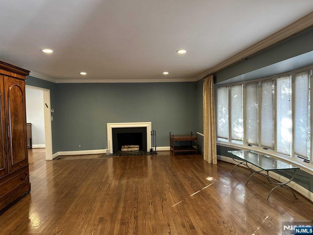 711 Camperdown Road Teaneck, NJ 07666 - Photo 2 of 12 a view of an empty room with a fireplace and wooden floor