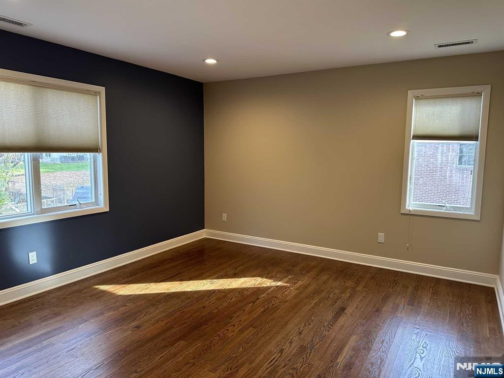 711 Camperdown Road Teaneck, NJ 07666 - Photo 8 of 12 an empty room with wooden floor and windows