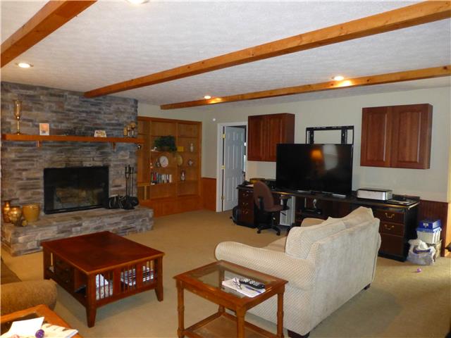 5501 Hunters Point Pike Lebanon, TN 37087 - Photo 5 of 14 Living room with stone fireplace, wood beam ceiling, recessed lights, built in bookcases on each side of fireplace and built in cabinets on back wall too!