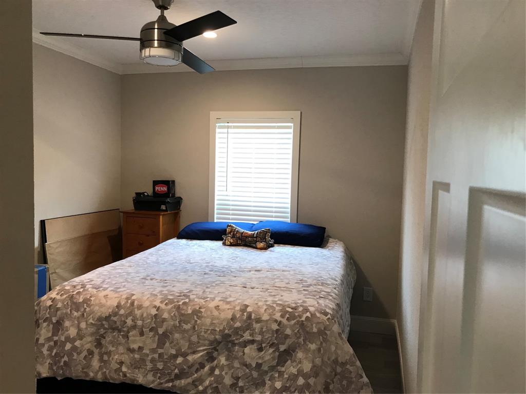 19418 Northwest 246th Street Okeechobee, FL 34972 - Photo 12 of 24 a bedroom with a bed and a chandelier