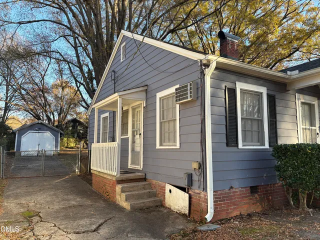 a view of a house with a yard and large tree