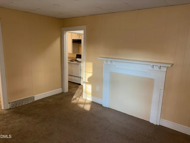 a view of empty room with a fireplace