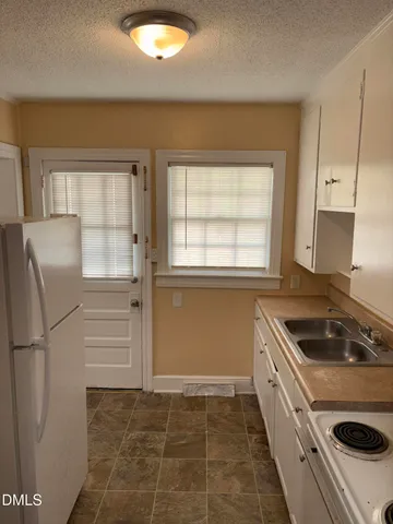 a kitchen that has a sink a refrigerator and window