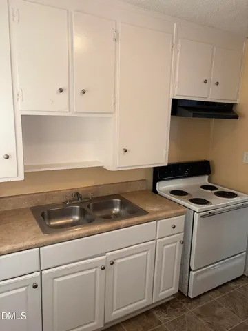 a kitchen with white cabinets and white appliances