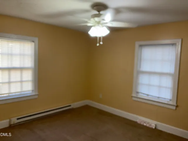 a view of a room with a chandelier fan and a window