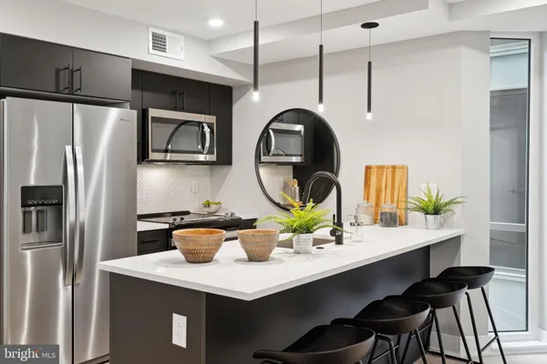 a kitchen with a table a refrigerator and cabinets