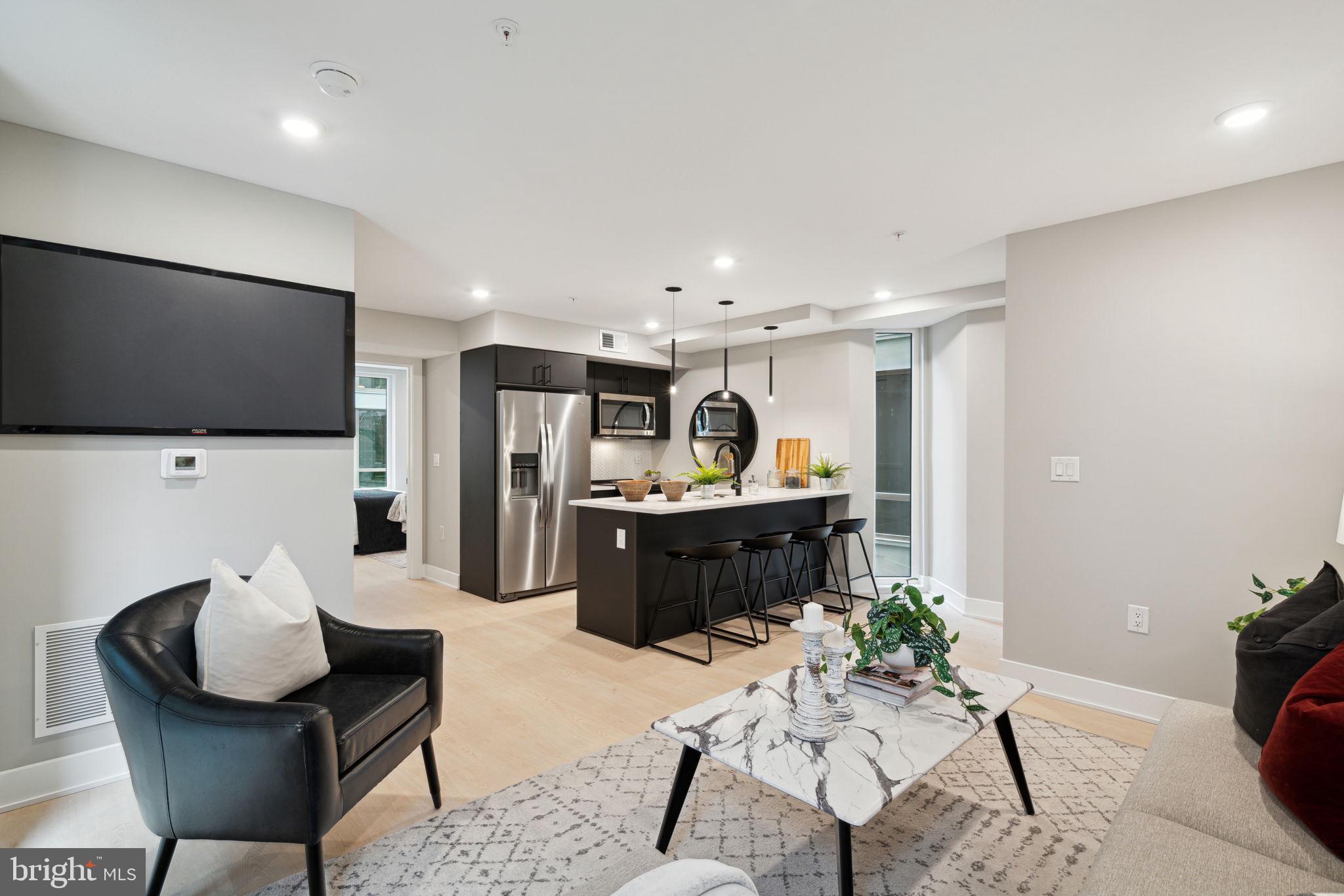 6604 Ridge Avenue, Unit 410 Philadelphia, PA 19128 - Photo 16 of 32 a living room with furniture and a flat screen tv