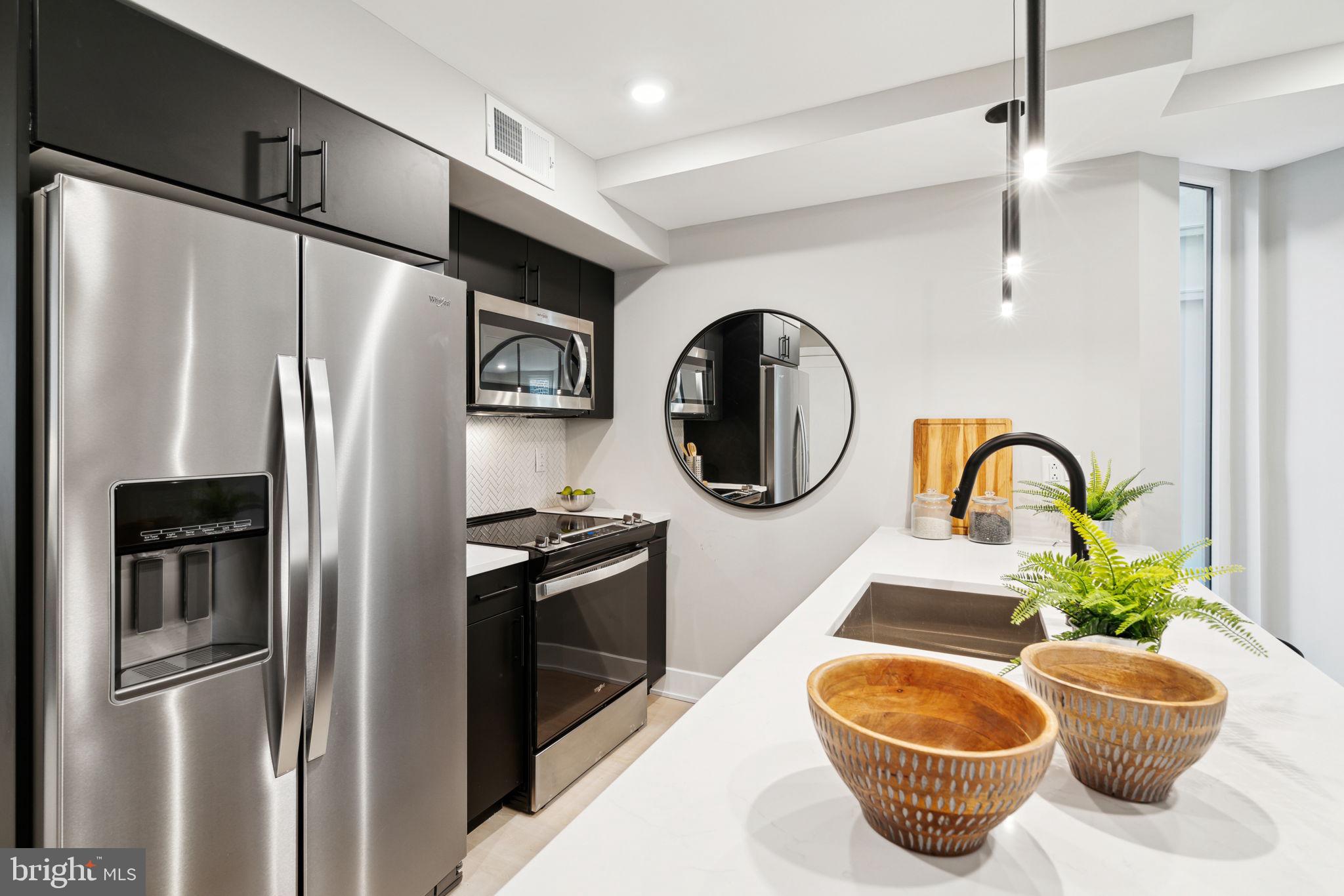 6604 Ridge Avenue, Unit 410 Philadelphia, PA 19128 - Photo 2 of 32 a kitchen with stainless steel appliances granite countertop a refrigerator a stove and a sink