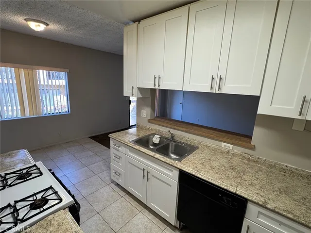 a kitchen with granite countertop a sink and a stove