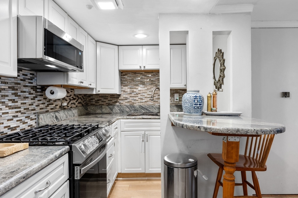 116 Sutherland Road, Unit 1A Boston, MA 02135 - Photo 11 of 21 a kitchen with stainless steel appliances granite countertop a stove a sink and a microwave