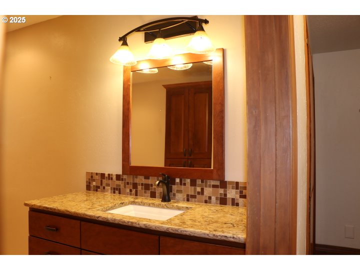 6503 Kinns Road Northeast Woodburn, OR 97071 - Photo 11 of 45 a bathroom with a granite countertop sink and a mirror